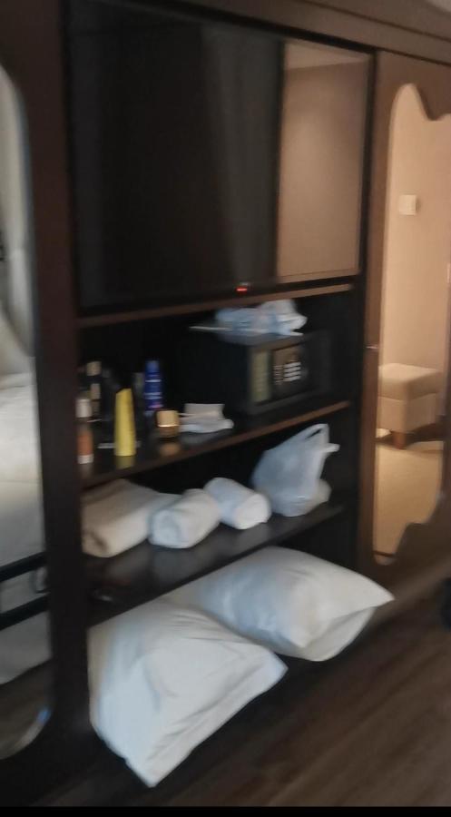 Buona Vitta Gramado Resort & Spa By Gramado Parks Exterior foto The photo shows a piece of furniture, likely a shelving unit or cabinet, with several items on it. There is a television mounted on top. Below the TV, there is a microwave and a small safe. The shelves contain various toiletries and personal care pro