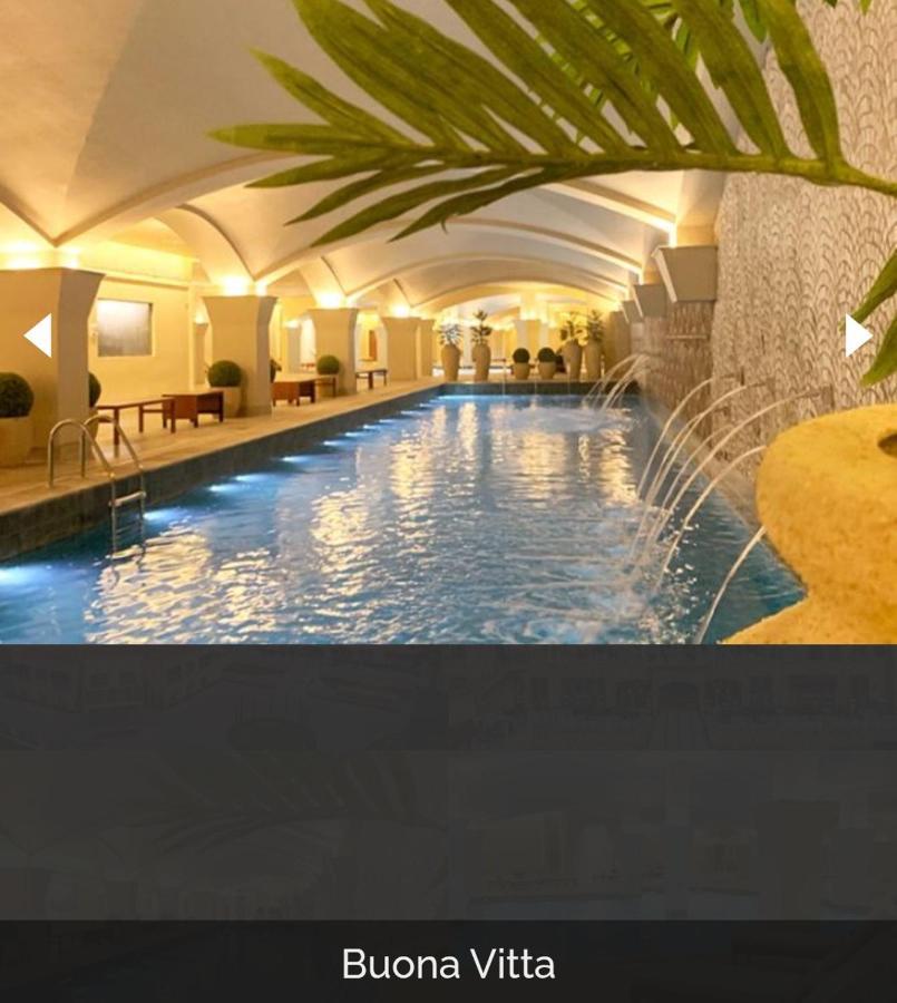 Buona Vitta Gramado Resort & Spa By Gramado Parks Exterior foto The photo depicts an elegant indoor swimming pool area. The pool is illuminated with lights along its edge, and there are gentle water features creating a calming atmosphere. The ceiling has an arched design, and the space is decorated with plants an