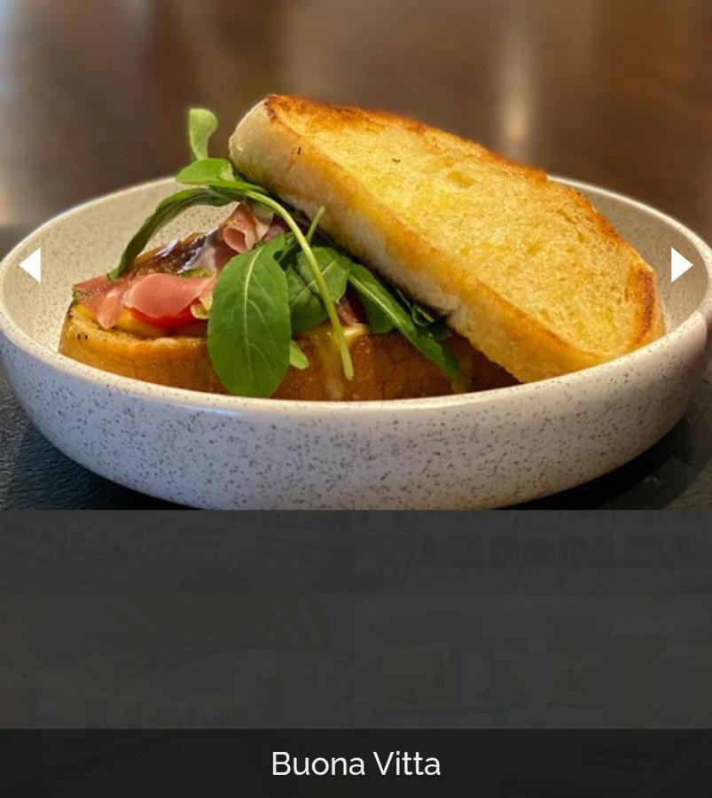 Buona Vitta Gramado Resort & Spa By Gramado Parks Exterior foto The photo shows a dish presented in a round, speckled bowl. It features a slice of toasted bread resting on top of a combination of ingredients beneath. The ingredients include leafy greens and slices of what appears to be cured meat, possibly ham. T