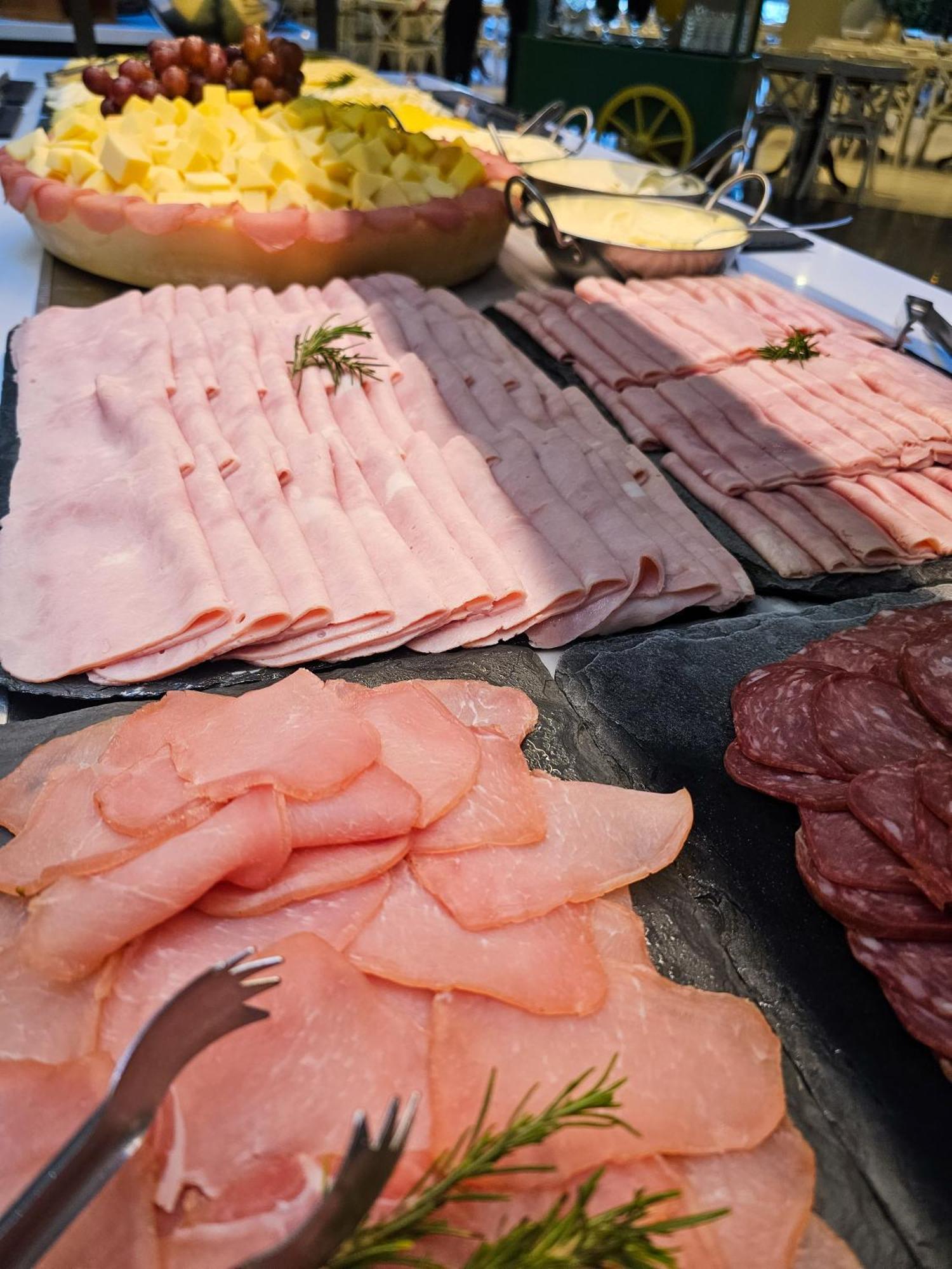 Buona Vitta Gramado Resort & Spa By Gramado Parks Exterior foto The photo shows a display of various types of sliced deli meats arranged on a flat surface. There are several layers of thinly sliced, pale-colored meats, likely including ham or turkey, organized neatly in parallel rows. Additionally, there are slic